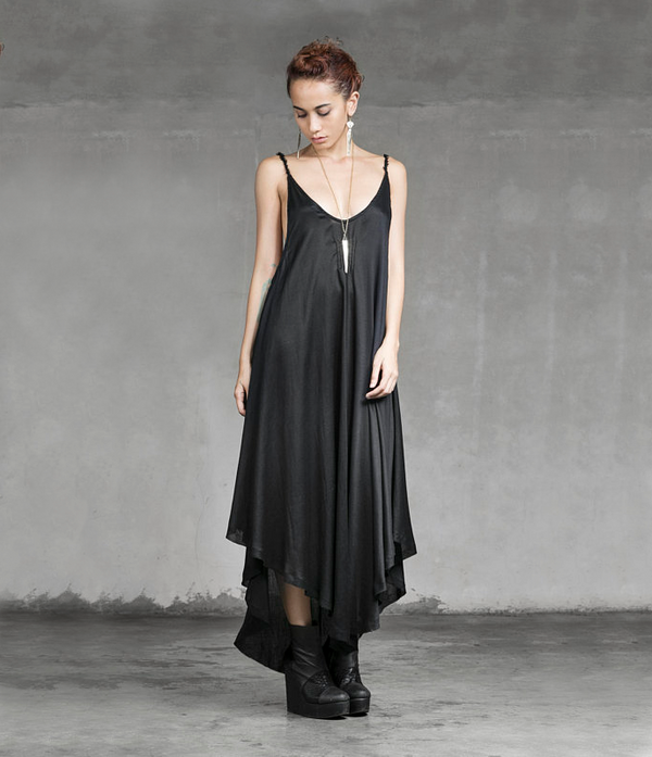 Women wearing a black, sheer & flowy bohemian open back dress paired with nouveau style brass earrings & pendant necklace.