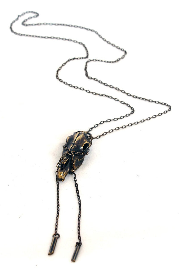 Skull-shaped pendant on a chain against a white background